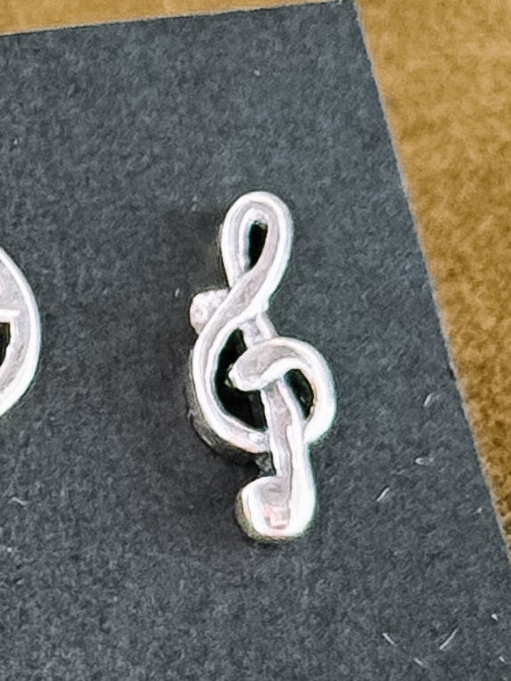 Set of silver earrings on a black card with a textured surface