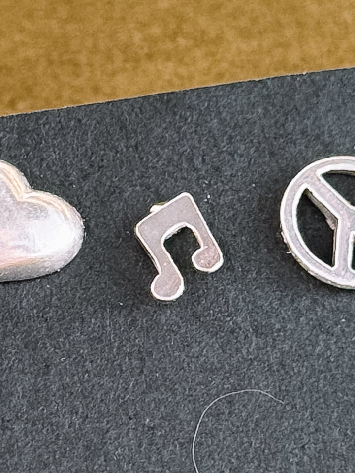 Set of silver earrings on a black card with a textured surface