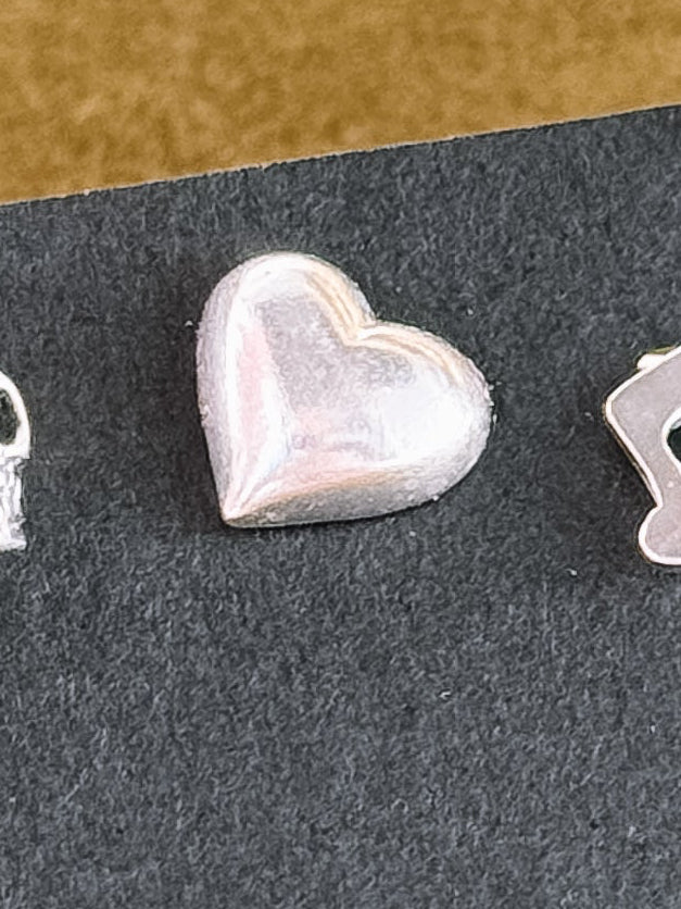 Silver lightning bolt-shaped earring on a dark background