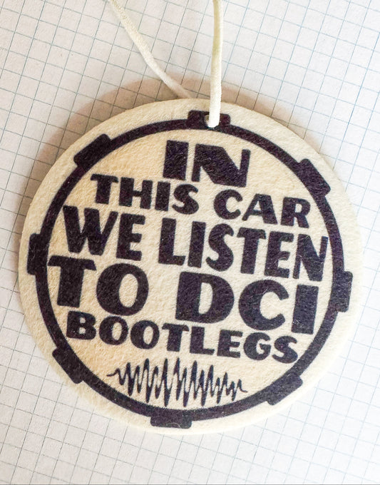 Round car air freshener with text 'In this car we listen to DCI Bootlegs' on a grid background
