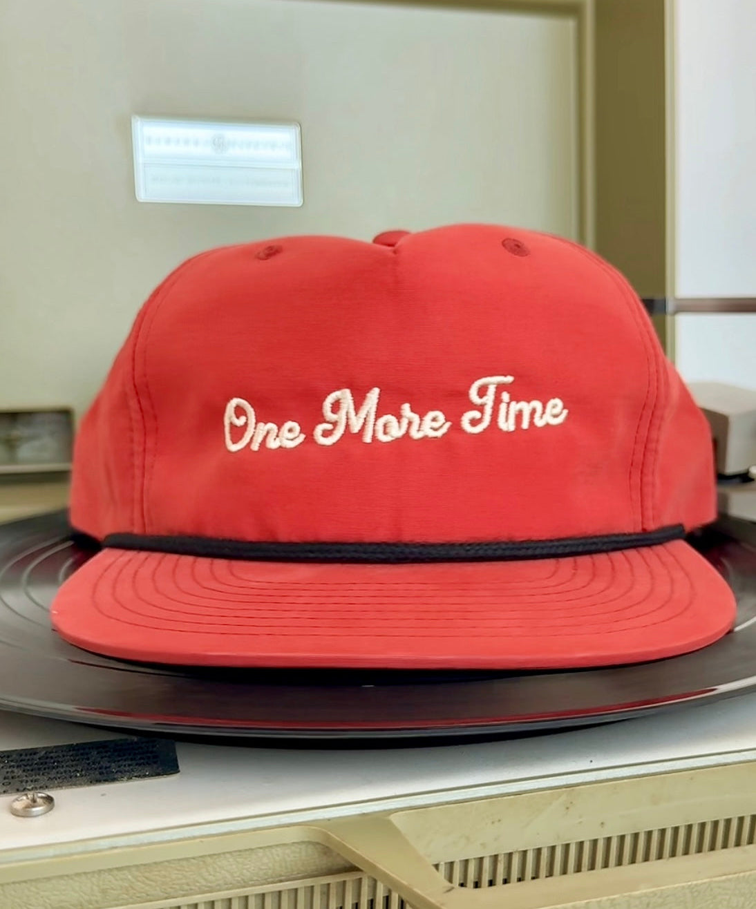 Orange Red cap with 'One More Time' text on a turntable